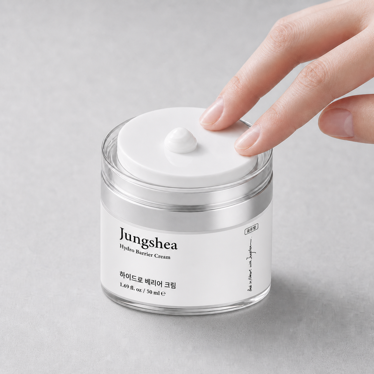Finger pressing the pump top of an open Jungshea moisturizer jar