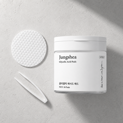 Jungshea exfoliating pads jar, textured pad, and white tweezers in a flat lay